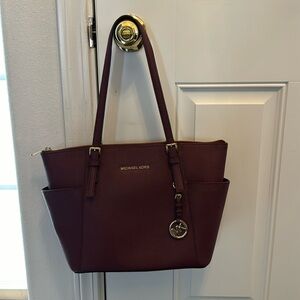 Michael Michael Kors Jet set top zipper with Saffiano burgundy leather.